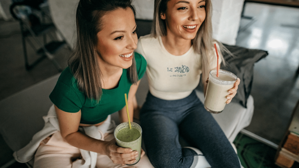 Deux membres du 20/80 Fit Club partagent un moment convivial avec leurs boissons nutrition. Parrainez vos amis !