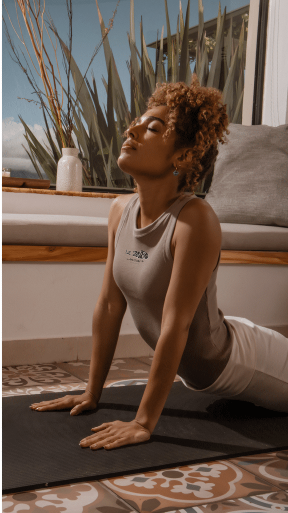 Femme pratiquant une posture de yoga dans une ambiance lumineuse et apaisante