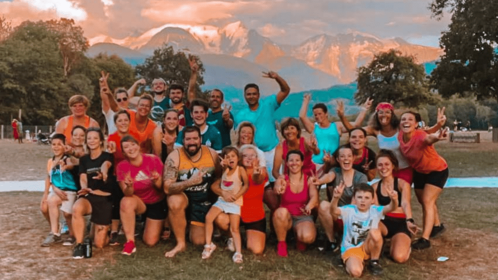 Photo de groupe du 20/80 Fit Club à Sallanches en plein air devant un massif montagneux au coucher du soleil