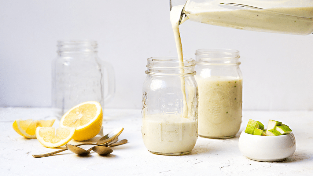 Vinaigrette crémeuse versée dans des bocaux en verre avec citron et avocat pour une activité et un atelier cuisine.